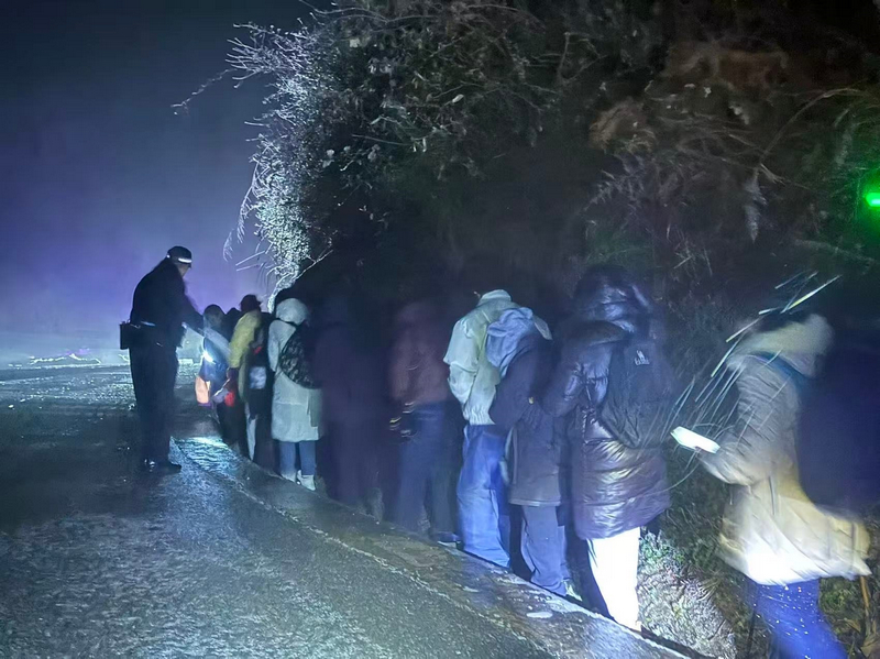 1月21日晚,救援人員組織被困游客離開凝凍路段。