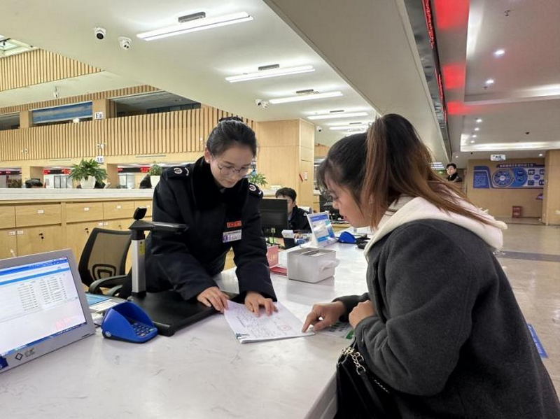 圖為 “疑難雜癥處理專窗”工作人員為納稅人辦理涉稅業務。李琪攝