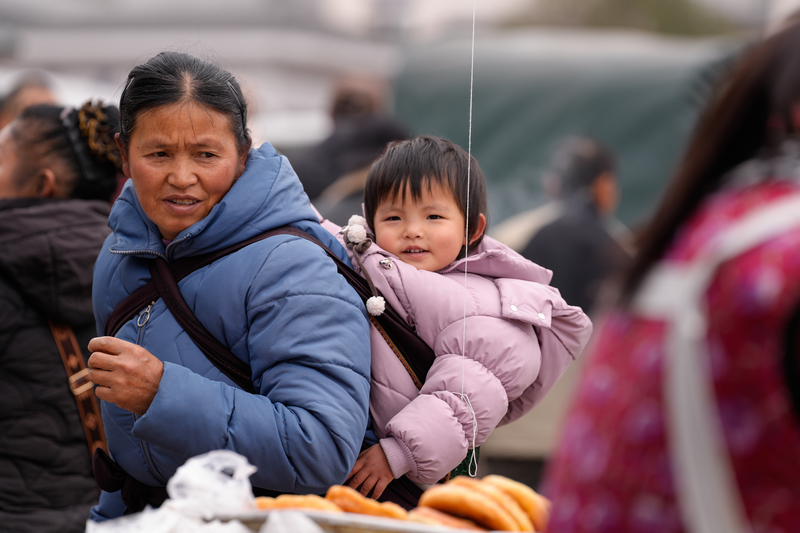 1月23日，凱里下司大集，開心地和奶奶一起逛大集的小女孩。