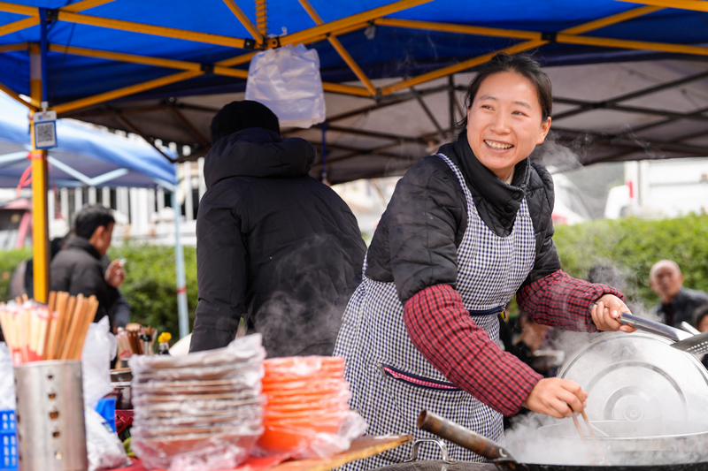 1月23日，凱里下司大集上粉攤老板娘看著生意來樂了。