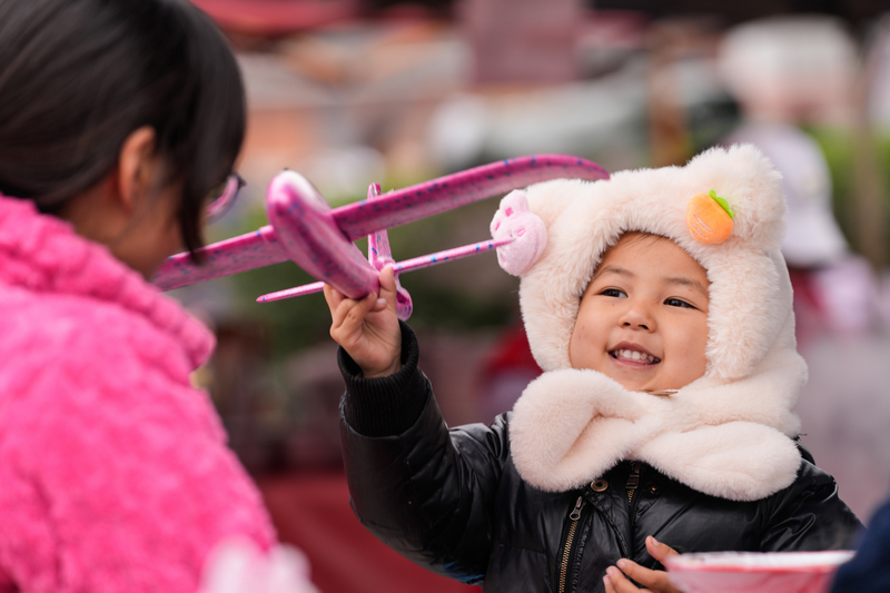 1月23日，凱里下司大集上小朋友開心地玩著媽媽給買的玩具。