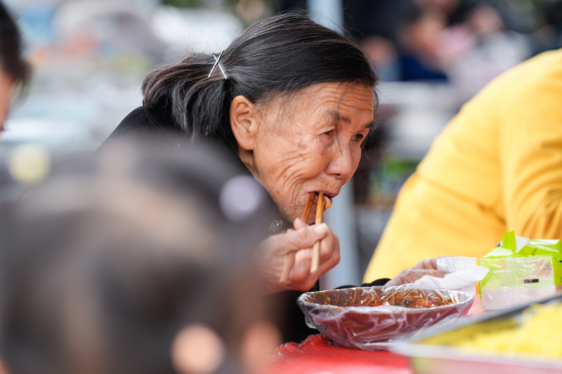 1月23日，凱里下司大集上一位80多歲的奶奶在吃著溫暖的米粉。