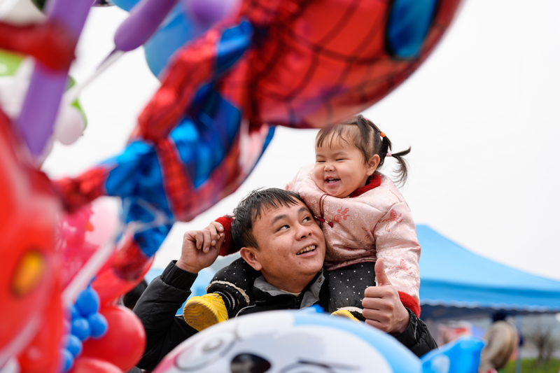 1月23日，凱里下司大集小女孩開心地坐在爸爸的肩膀上。