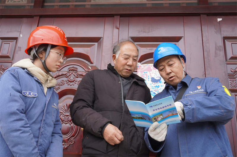 臺區經理帶著青年團員一同前往客戶家中進行用電安全宣傳。