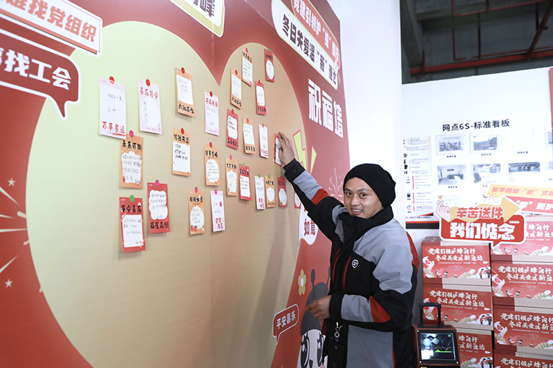 快遞員在祝福墻貼下寄語。