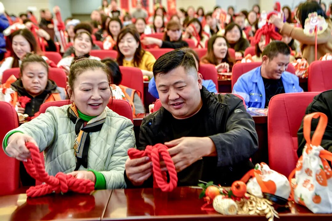 在老師的指導下,職工們認真制作中國結。