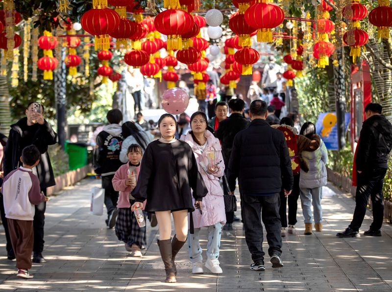 市民在掛滿紅燈籠的黔西市水西公園游玩。