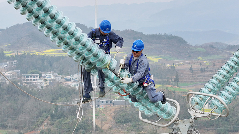 工作人員在輸電線路鐵塔上更換絕緣子。