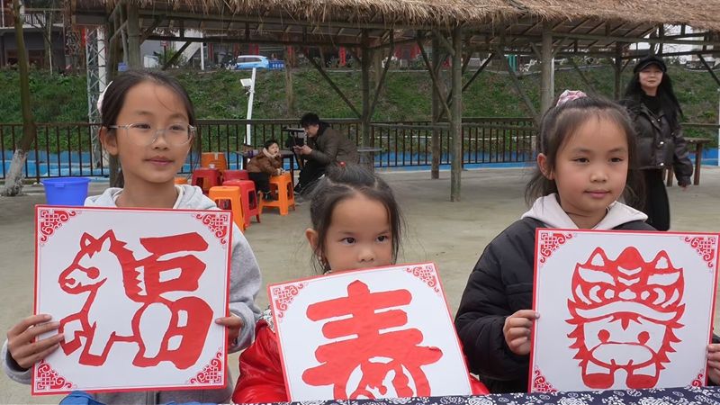 游客展示自己剪的剪紙作品。