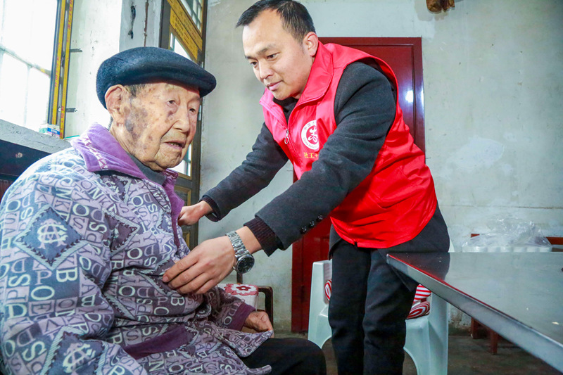 貴州省遵義市播州區(qū)龍坑街道八里社區(qū)黨員干部為102歲淳祖開(kāi)老人拉家常，幫助老人整理衣服。