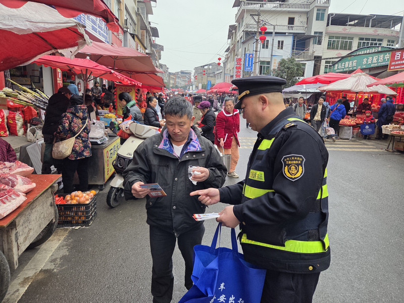 在三穗縣瓦寨鎮(zhèn),執(zhí)法人員向過往群眾普法宣傳。