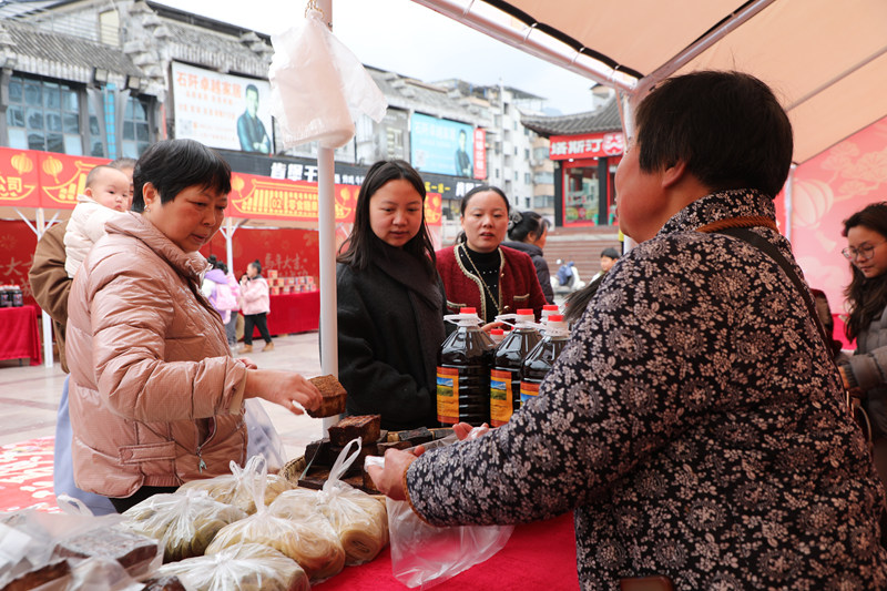 顧客在石阡縣年貨市場選購豆干。