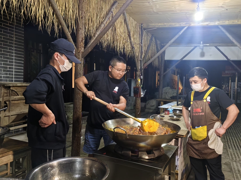 2 圖為劉偉與學員一起研究屯堡美食。李磊 攝.jpg
