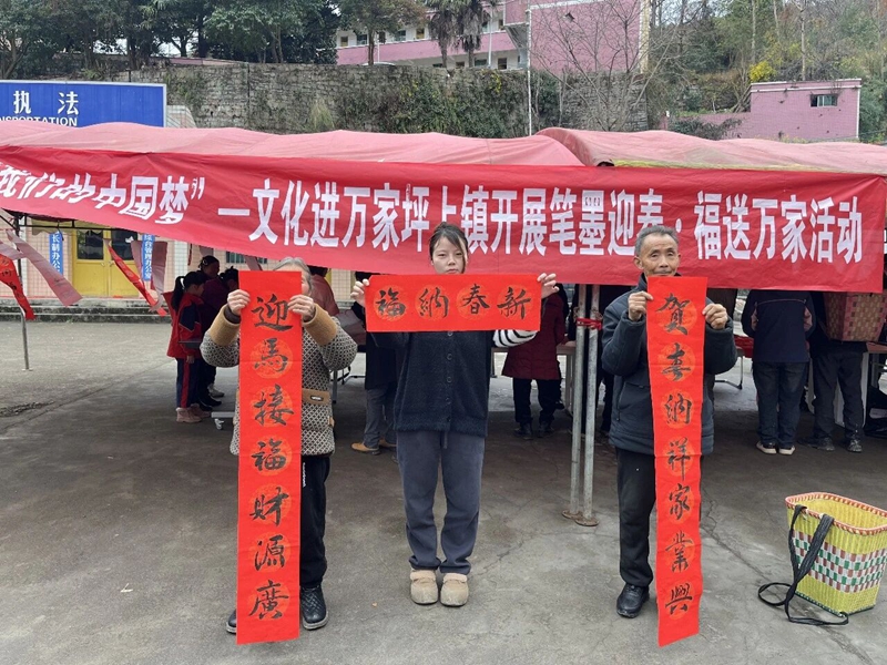 1 圖為村民們展示書法家們書寫的春聯.jpg