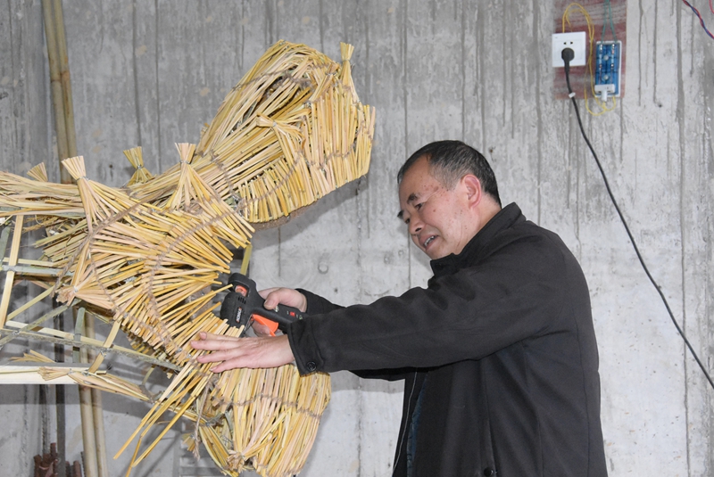 施秉縣社區(qū)手藝人在編制草把龍的龍頭.JPG