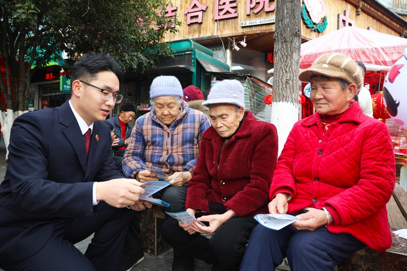 2026年2月11日，施秉縣檢察院干警在給前來采購年貨的群眾講解預(yù)防養(yǎng)老詐騙宣傳知識。吳桂花攝