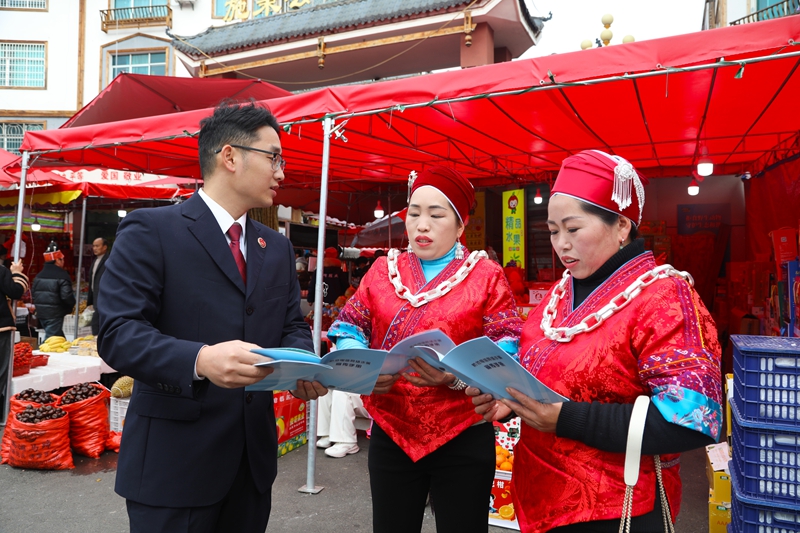 2026年2月11日，施秉縣檢察院干警在給前來采購年貨的群眾講解相關法律知識。吳桂花攝