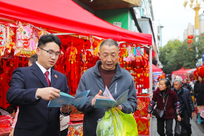 2026年2月11日，施秉縣檢察院干警在給前來采購年貨的群眾講解相關法律知識。吳桂花攝