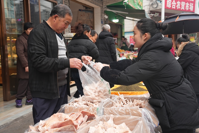 2、村民們正挑選著自己心儀的年貨，攤主們熱情推銷介紹，煙火氣十足。