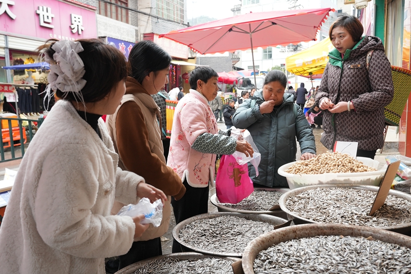 3、村民們正挑選著自己心儀的年貨，攤主們熱情推銷介紹，煙火氣十足。