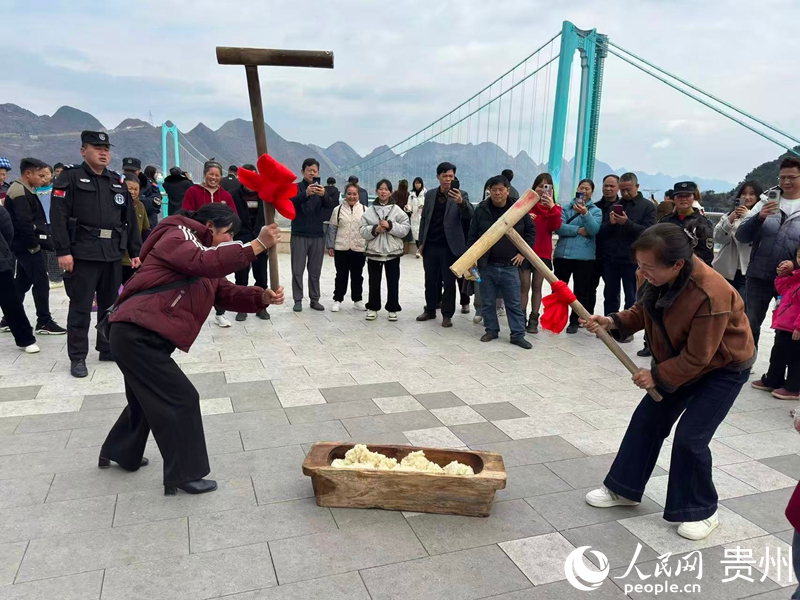 游客以大橋為背景參與打糍粑。人民網記者 高華攝
