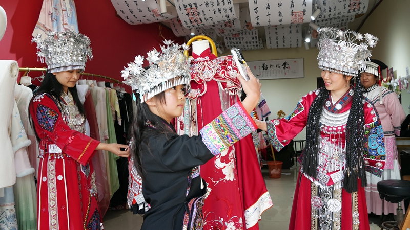 2026年2月20日,游客在江家灣碼頭選購民族服飾。岳剛攝