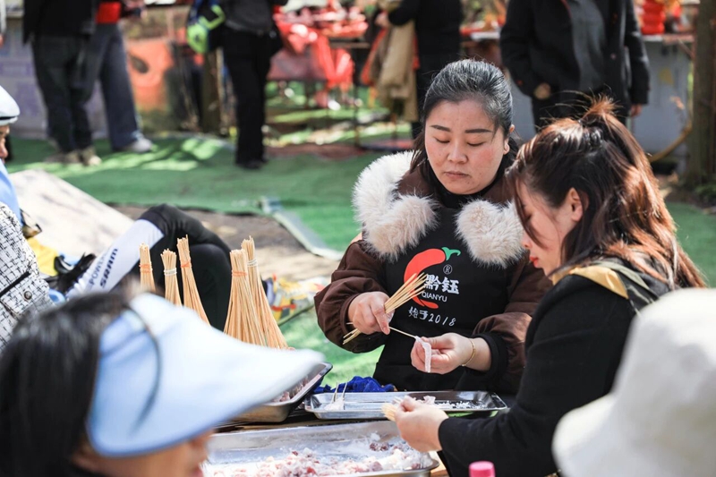 9、龍娜與家人在櫻花樹下穿肉串。