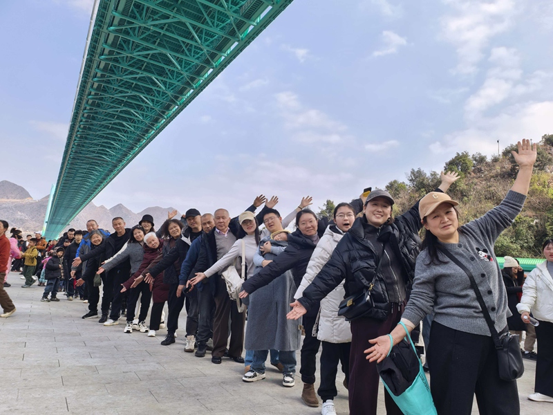 春節(jié)期間,在橋塔區(qū)排隊上橋的游客合影。黃飛鴻 攝