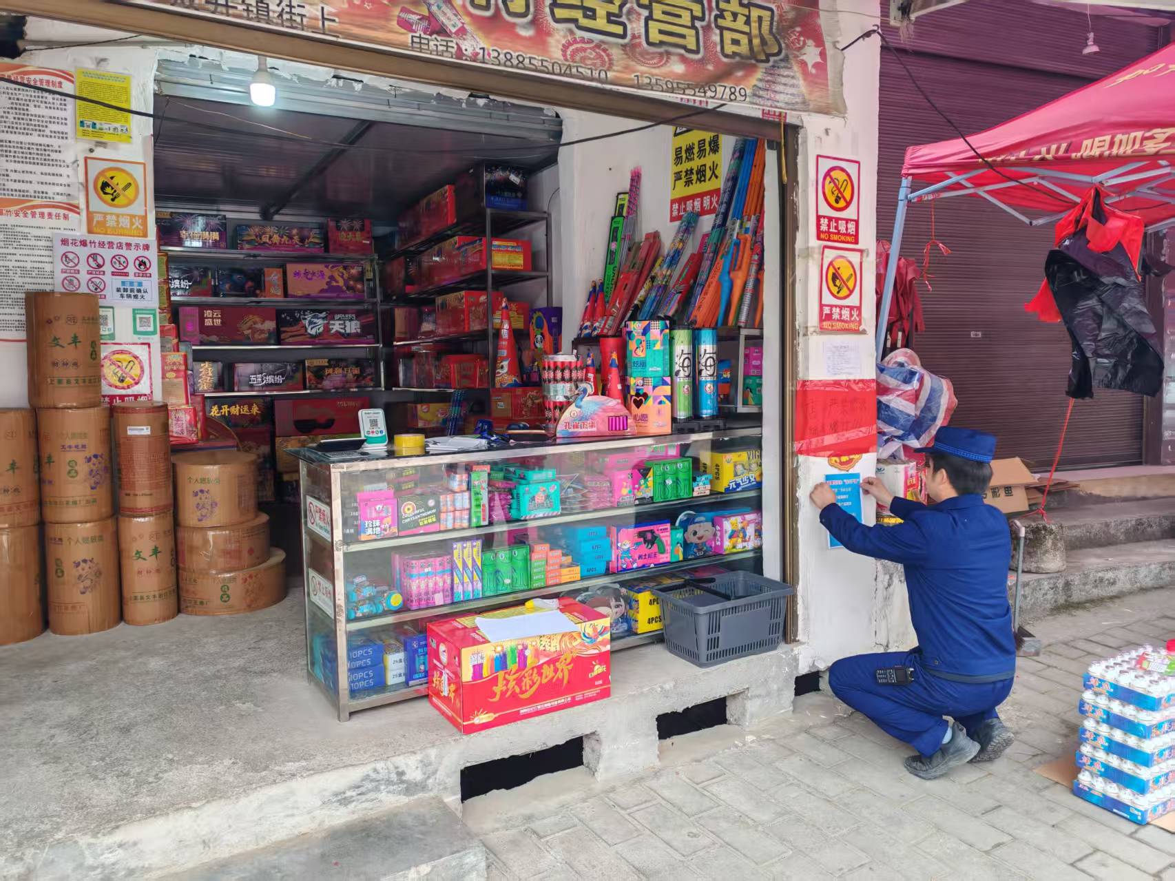 專職消防員在煙花爆竹門店門口張貼“五嚴禁、三務必”措施。