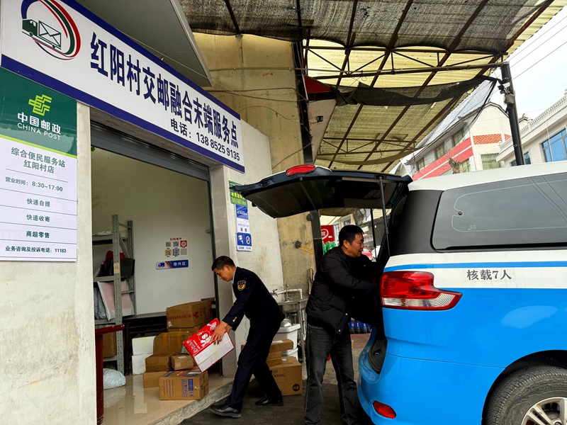 4、公交到達大壩鎮紅陽村交郵融合末端服務點, 負責人在下貨。