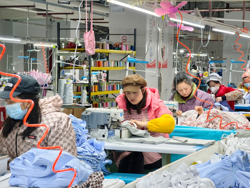 喻忠梅(左二)在服裝廠工作