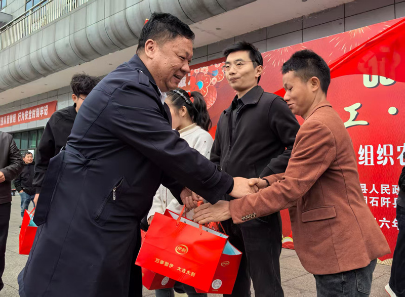 石阡縣總工會黨組書記、常務副主席安冰正在為外出務工人員發放“溫暖包”。