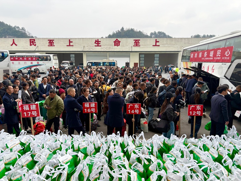 1、務工人員攜帶行囊,在工作人員引導下有序排隊登車。