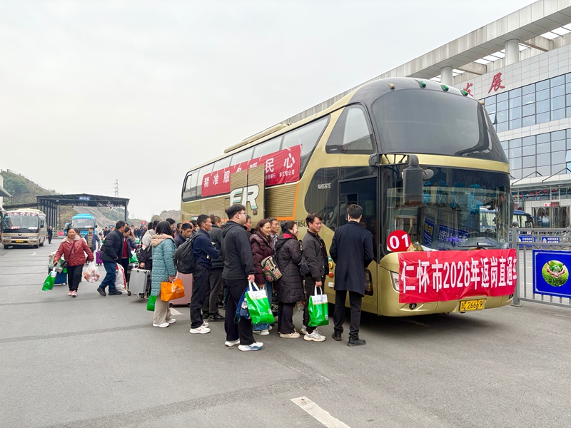 3、務工人員攜帶行囊,在工作人員引導下有序排隊登車。