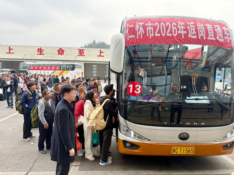 4、務工人員攜帶行囊,在工作人員引導下有序排隊登車。