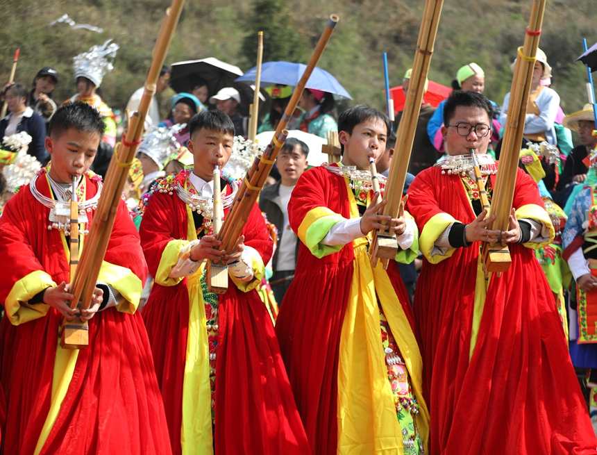苗族青年在跳月場吹蘆笙。