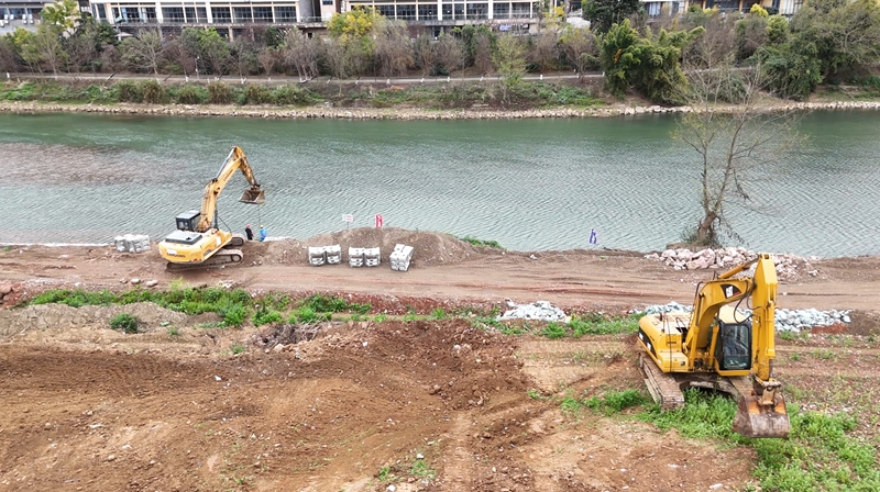 工人們正在進行土方平整與生態框安裝作業。.jpg