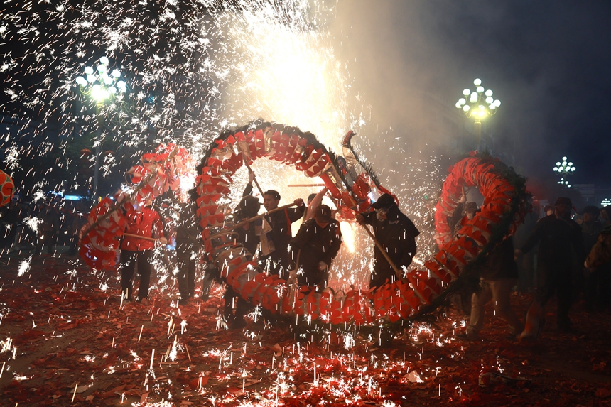 2月27日晚，貴州省黔東南苗族侗族自治州施秉縣城街頭，社區龍燈隊的漢子們在噴射的噓花中舞動“亮龍”。 