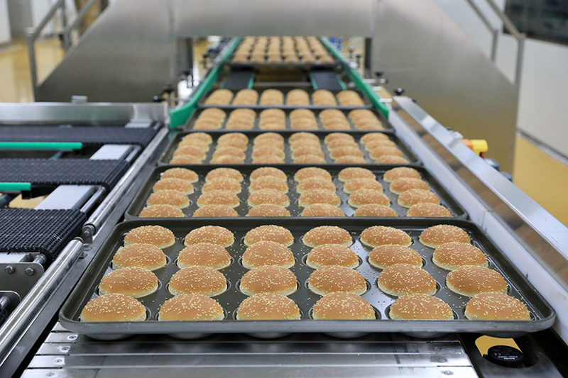 華萊士烘焙食品生產基地漢堡生產車間內，剛出爐的漢堡胚。