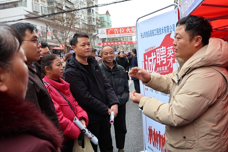 圖為：浙江企業(yè)工作人員介紹公司招聘信息