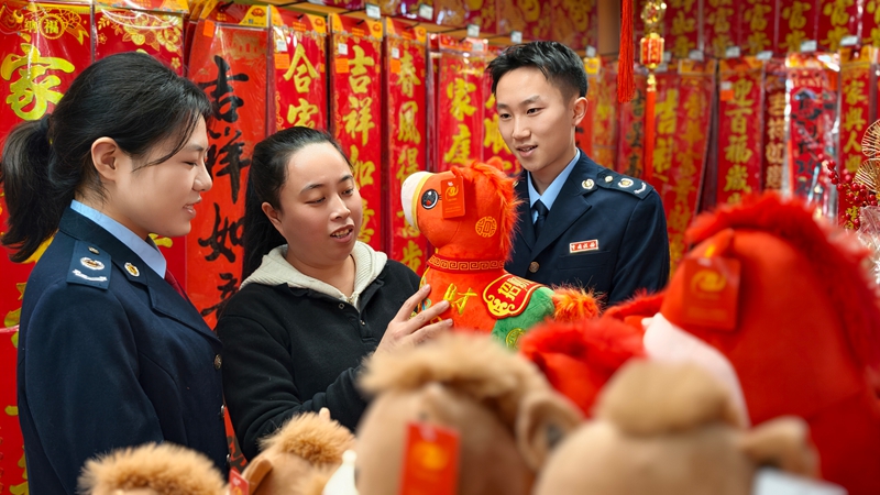 5 圖為北京華聯生活超市工作人員向稅務干部介紹年貨預備情況及銷售情況 張暉攝.jpg