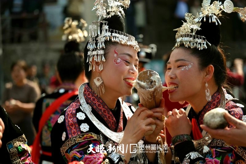 2025年10月29日,錦屏縣河口鄉文斗村村民,身著民族盛裝在廣場上品嘗打好的糍粑。李斌 攝