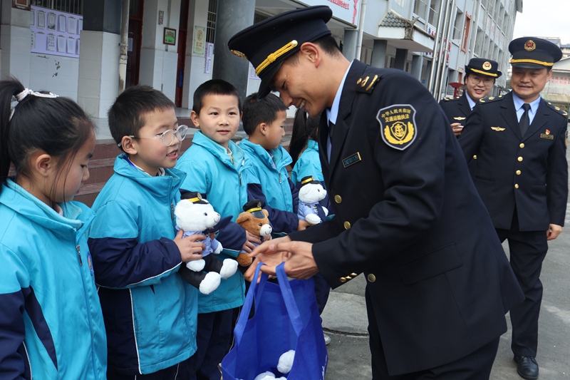 3 圖為執(zhí)法人員向小學生發(fā)放小禮品 。