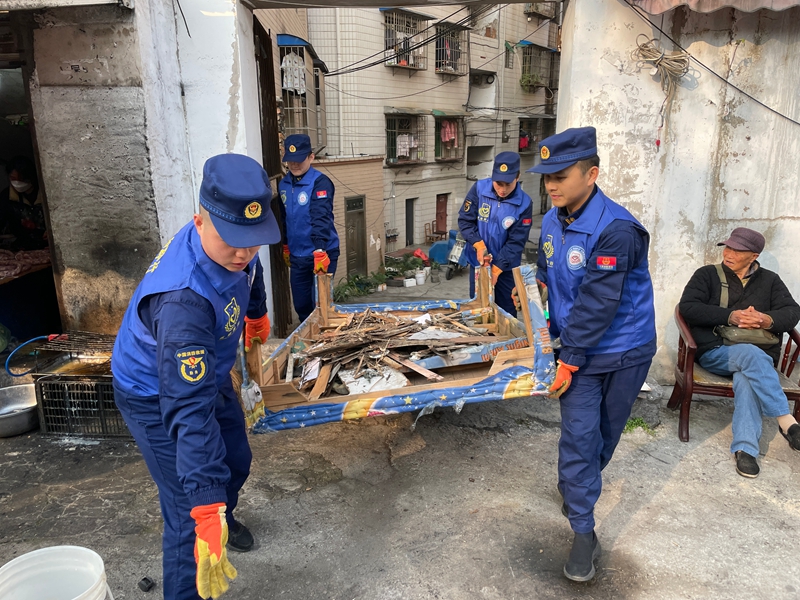 圖為廣建路消防員為老舊小區(qū)清理樓道雜物.jpg