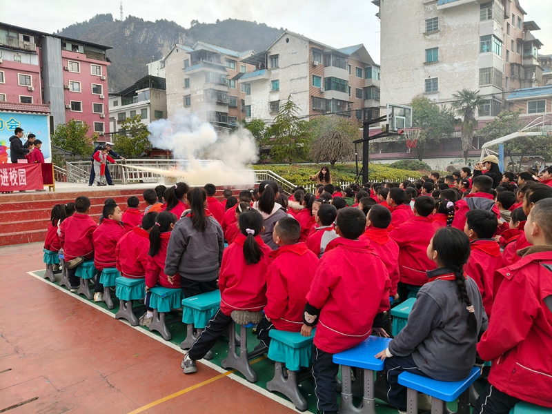 施秉縣消防宣傳員在施秉縣第二小學教學生使用滅火器。