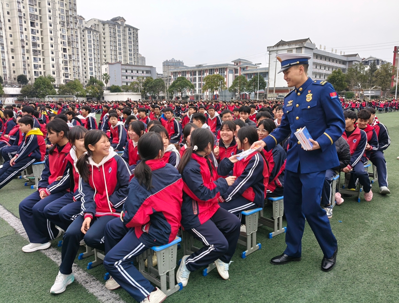 施秉縣消防宣傳員在施秉縣民族中學向學生發放《中小學生消防安全知識讀本》。