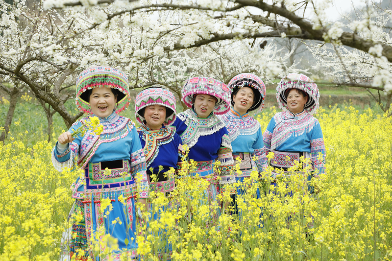 當地村民身穿自身少數民族在油菜花田里游玩 。姜繼恒攝