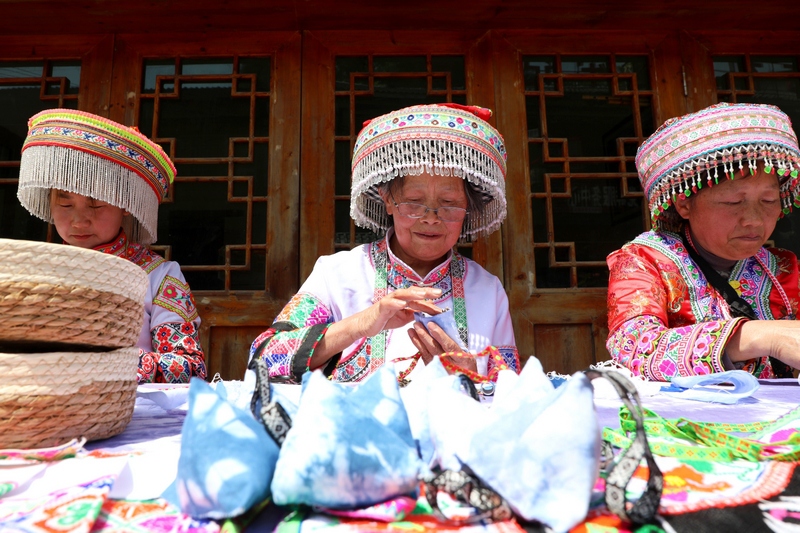 7、馬鬃鄉(xiāng)繡娘縫制蠟染“粽子香包”。陳桂良攝