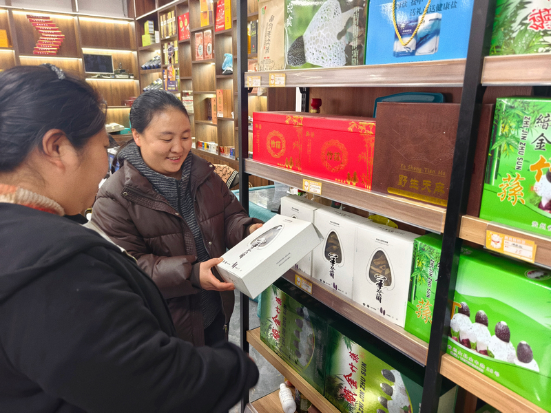 倪青青給游客介紹特產(chǎn)。