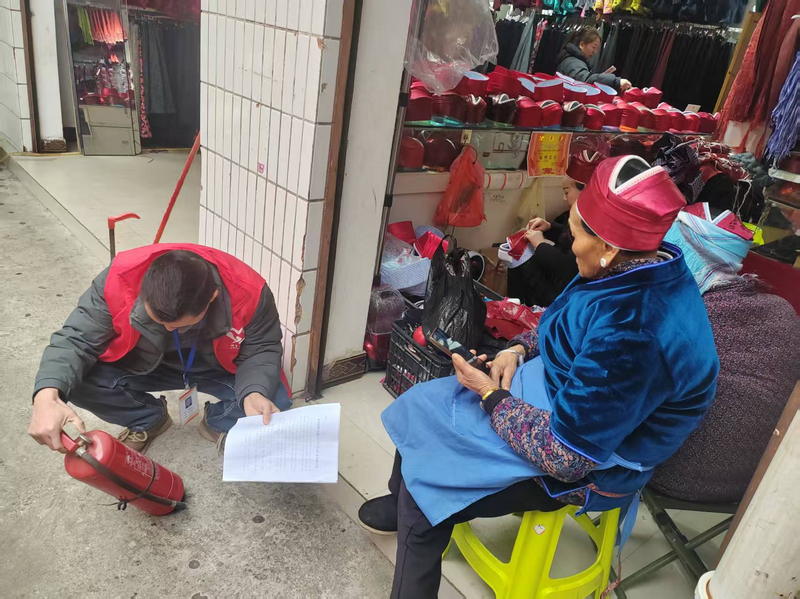施秉縣城關(guān)鎮(zhèn)工作人員在商鋪認(rèn)真查看滅火器有效期。